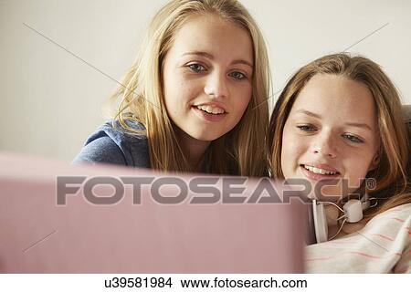 Two girls on sofa using digital tablet View Large Photo Image Picture - Two girls on sofa using digital tablet. Fotosearch