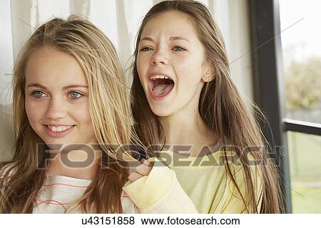Two girls smiling and shouting from shelter View Large Photo Image Stock Photo - Two girls smiling and shouting from shelter. Fotosearch