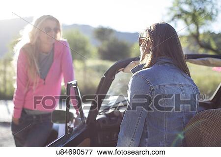 "Two mature women, talking, beside convertible car" View Large Photo Image Stock Photo - "Two mature women, talking, beside convertible car". Fotosearch