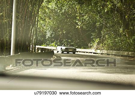 "Two men in convertible car on road, rear view" View Large Photo Image Stock Image - "Two men in convertible car on road, rear view". Fotosearch