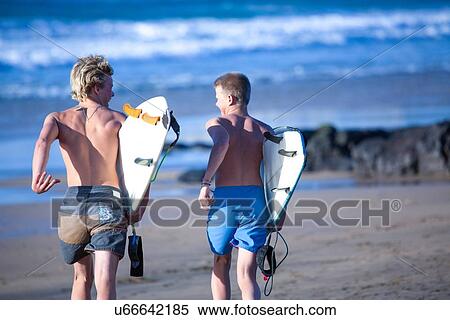 "Two teenage male surfers running toward sea, Fuerteventura, Spain" View Large Photo Image Stock Photography - "Two teenage male surfers running toward sea, Fuerteventura, Spain". Fotosearch