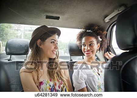 "Two young women in back of car, smiling" View Large Photo Image Stock Photo - "Two young women in back of car, smiling". Fotosearch