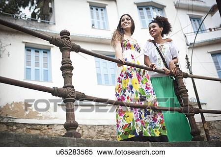 "Two young women standing by railings, low angle view" View Large Photo Image Stock Photography - "Two young women standing by railings, low angle view". Fotosearch