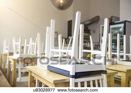 Stock Photo - Upside down chairs on table in cafe. Fotosearch