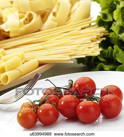 Variety of raw pasta and fresh vine tomatoes View Large Photo Image Stock Photo - Variety of raw pasta and fresh vine tomatoes. Fotosearch