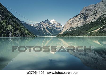 Stock Photograph - "View of lake, forests and snow capped mountain, British Columbia, Canada". Fotosearch