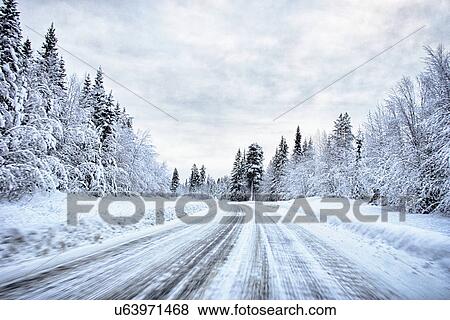 Stock Photo - "View of snow covered forest highway, Hemavan, Sweden". Fotosearch