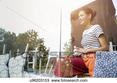 Stock Image - Waitress taking break in cafe. Fotosearch