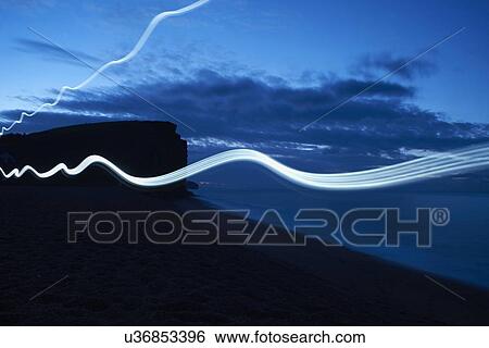 Wavy line light trails on silhouetted beach at night View Large Photo Image Stock Photograph - Wavy line light trails on silhouetted beach at night. Fotosearch