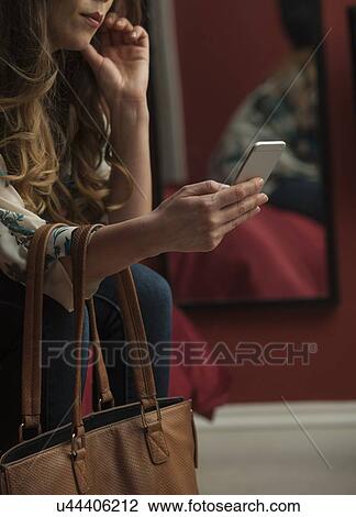 Woman looking at smartphone cropped View Large Photo Image Stock Image - Woman looking at smartphone cropped. Fotosearch