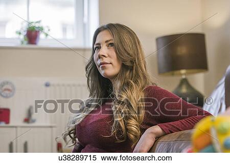 Woman relaxing at home looking away View Large Photo Image Stock Photography - Woman relaxing at home looking away. Fotosearch