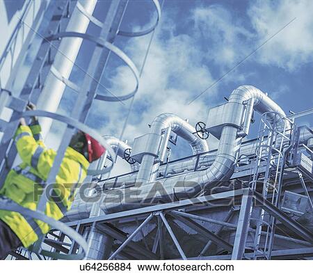 Picture - "Worker at gas fired power station, low angle view". Fotosearch