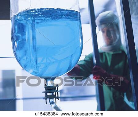 Picture - "Worker mixing chemical in factory, close up". Fotosearch