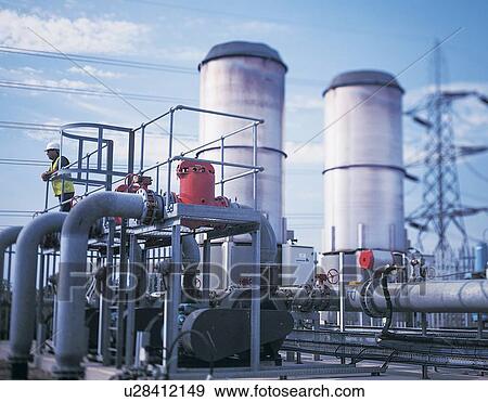 Worker standing by gas generator in recycling plant View Large Photo Image Stock Photo - Worker standing by gas generator in recycling plant. Fotosearch