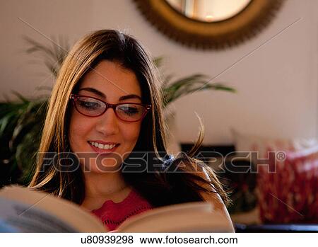 Young adult female with glasses reading book View Large Photo Image Stock Photo - Young adult female with glasses reading book. Fotosearch
