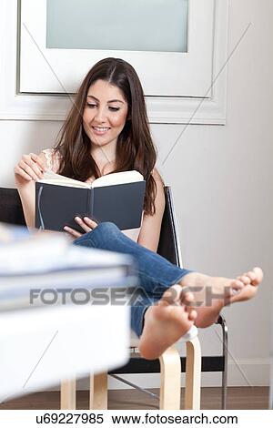 Young adult woman reading book with feet up View Large Photo Image Stock Photography - Young adult woman reading book with feet up. Fotosearch