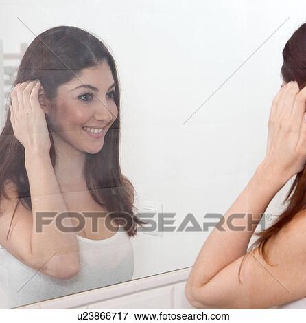 Young adult woman smiling into mirror View Large Photo Image Stock Photo - Young adult woman smiling into mirror. Fotosearch