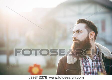 "Young bearded man, building in background" View Large Photo Image Stock Photograph - "Young bearded man, building in background". Fotosearch