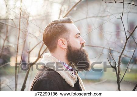 Stock Photograph - Young bearded man in park. Fotosearch