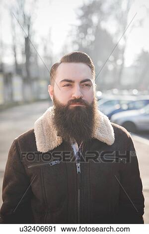 Stock Image - Young bearded man on street. Fotosearch