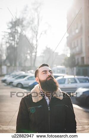 Stock Photo - Young bearded man on street. Fotosearch