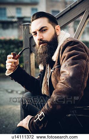 Young bearded man smoking pipe on steps View Large Photo Image Stock Image - Young bearded man smoking pipe on steps. Fotosearch