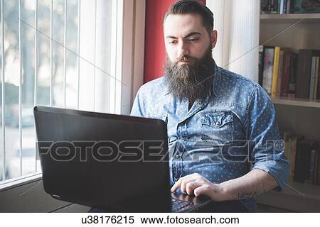 Young bearded man using laptop on floor View Large Photo Image Stock Photography - Young bearded man using laptop on floor. Fotosearch