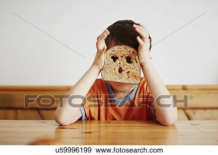Young boy covering face with toast View Large Photo Image Stock Photo - Young boy covering face with toast. Fotosearch