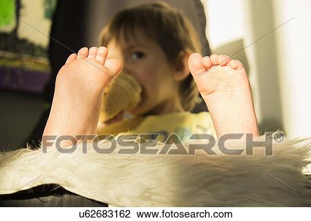 "Young boy drinking from beaker, focus on feet" View Large Photo Image Stock Image - "Young boy drinking from beaker, focus on feet". Fotosearch