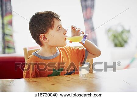 Young boy drinking glass of juice View Large Photo Image Stock Image - Young boy drinking glass of juice. Fotosearch