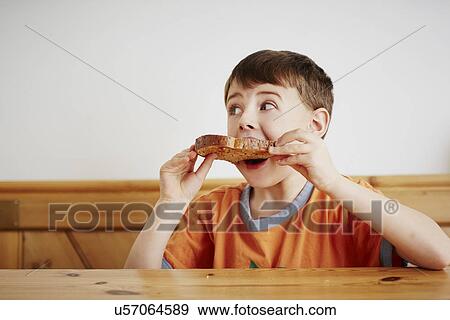 Young boy eating piece of toast View Large Photo Image Stock Photo - Young boy eating piece of toast. Fotosearch