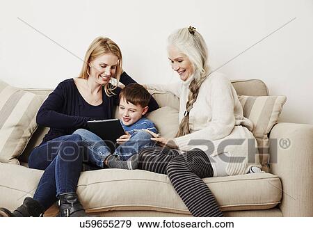 Young boy using digital tablet with mother and grandmother View Large Photo Image Stock Photo - Young boy using digital tablet with mother and grandmother. Fotosearch
