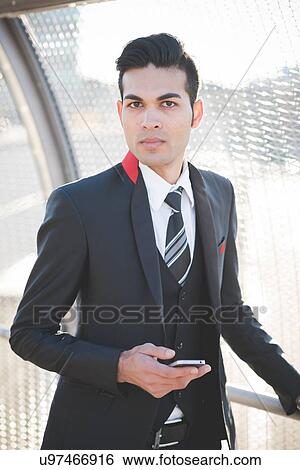 Stock Photograph - Young businessman by bridge safety fence. Fotosearch
