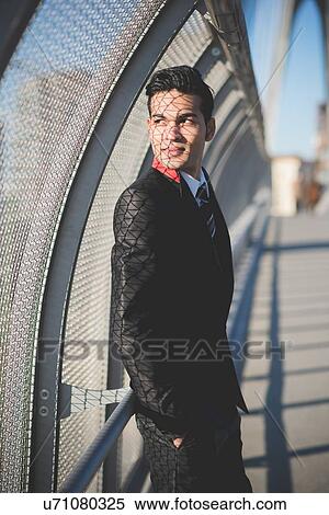 Stock Photography - Young businessman by bridge safety fence. Fotosearch