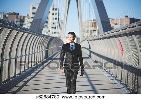 Young businessman crossing bridge View Large Photo Image Stock Image - Young businessman crossing bridge. Fotosearch