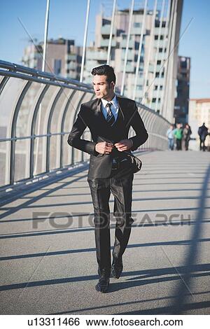 Young businessman crossing bridge View Large Photo Image Stock Photograph - Young businessman crossing bridge. Fotosearch