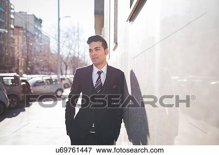 Young businessman leaning against wall View Large Photo Image Stock Photo - Young businessman leaning against wall. Fotosearch