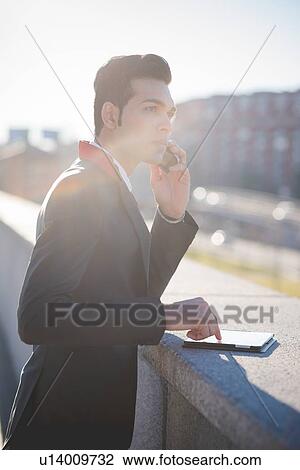 Young businessman using digital tablet on rooftop View Large Photo Image Stock Image - Young businessman using digital tablet on rooftop. Fotosearch