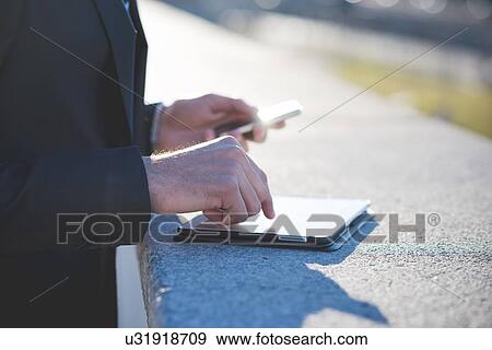 Young businessman using digital tablet on rooftop View Large Photo Image Stock Photo - Young businessman using digital tablet on rooftop. Fotosearch