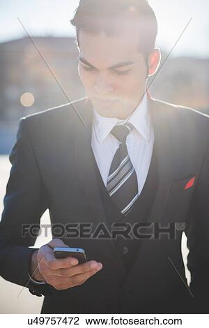Young businessman using smartphone View Large Photo Image Stock Image - Young businessman using smartphone. Fotosearch