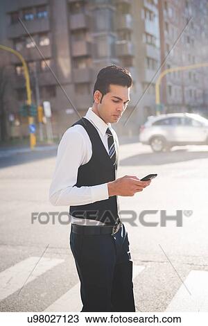 Young businessman using smartphone View Large Photo Image Stock Image - Young businessman using smartphone. Fotosearch