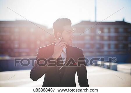 Young businessman using smartphone View Large Photo Image Stock Photo - Young businessman using smartphone. Fotosearch