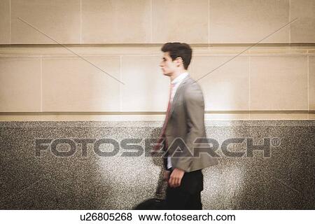 Young city businessman walking on sidewalk View Large Photo Image Stock Photo - Young city businessman walking on sidewalk. Fotosearch