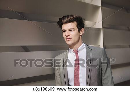 Young city businessman walking outside office View Large Photo Image Stock Photo - Young city businessman walking outside office. Fotosearch