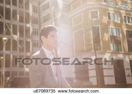 Young city businessman walking outside office building View Large Photo Image Stock Photography - Young city businessman walking outside office building. Fotosearch