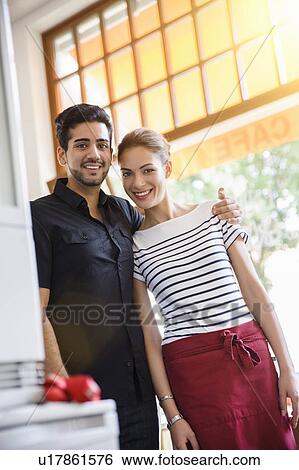 Young couple at work smiling at camera View Large Photo Image Stock Photograph - Young couple at work smiling at camera. Fotosearch
