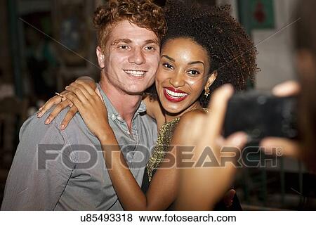 "Young couple having picture taken in bar, smiling" View Large Photo Image Stock Photo - "Young couple having picture taken in bar, smiling". Fotosearch