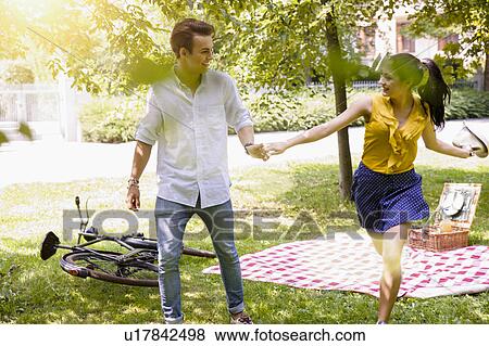 Young couple holding hands running View Large Photo Image Stock Photo - Young couple holding hands running. Fotosearch