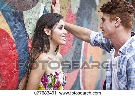 "Young couple, leaning against wall, face to face, smiling" View Large Photo Image Stock Image - "Young couple, leaning against wall, face to face, smiling". Fotosearch