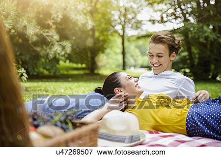 Young couple lying together on picnic blanket View Large Photo Image Stock Photo - Young couple lying together on picnic blanket. Fotosearch